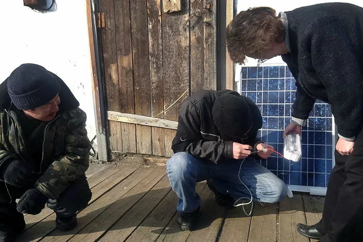 Turvaurgin Solar Panel Expert Maria Krivashapkina and reindeer herders review and assemble the recently arrived equipment in the village of Kolymskaya, Lower Kolyma, Republic of Sakha-Yakutia, Russia.