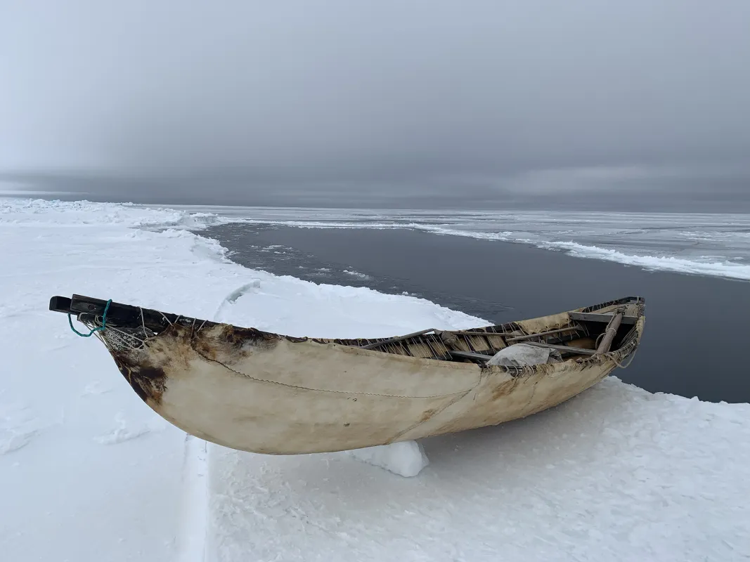 Whaling boat rests on the coastal shorefast sea ice