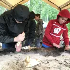 Children scrape a moose hide after learning the proper technique. Children scrape a moose hide after learning the proper technique.